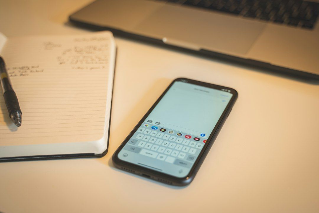 Téléphone et carnet de notes posés sur un bureau pour une demande de rendez-vous