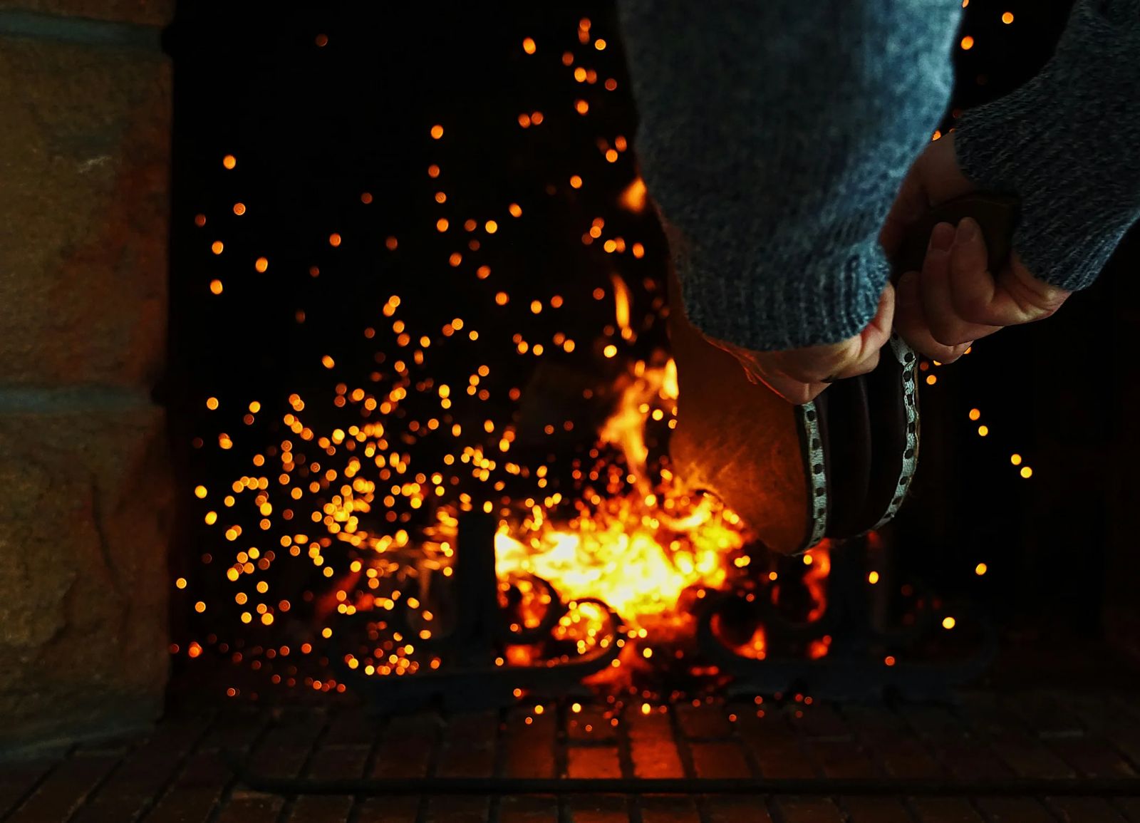 Première flambée dans une cheminée ramonée, étincelles au-dessus des braises